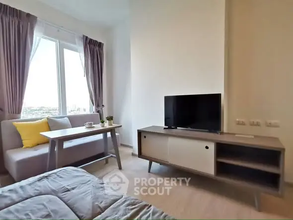 Modern living room with cozy sofa, TV stand, and large window with city view.