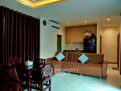 Modern open-plan living room with stylish furniture and integrated kitchen.