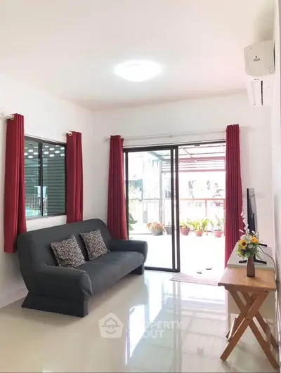 Bright living room with modern decor and large sliding glass doors leading to a balcony.