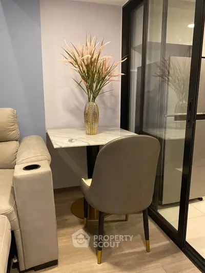 Cozy corner with elegant marble table and plush chair in modern apartment.