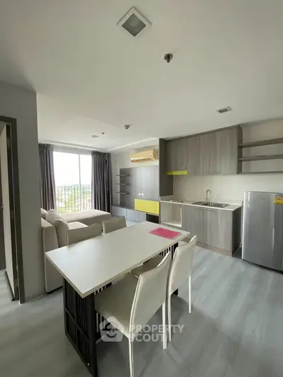 Modern open-plan living room and kitchen with sleek design and natural light.