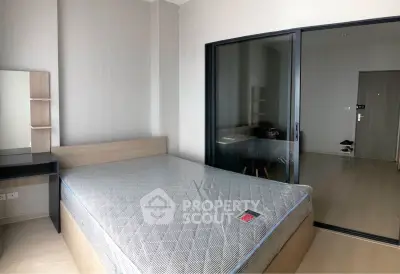 Modern bedroom with sleek design and glass partition in a contemporary apartment.