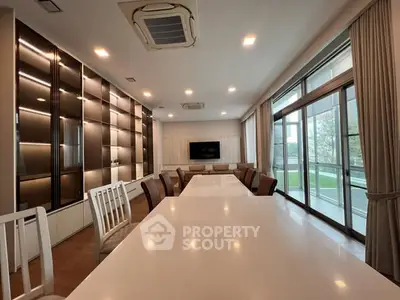 Spacious modern living room with large windows and elegant dining area
