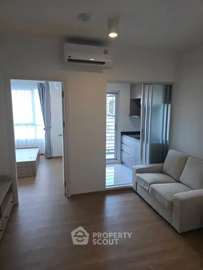 Modern apartment interior with cozy living room and adjacent kitchen area.