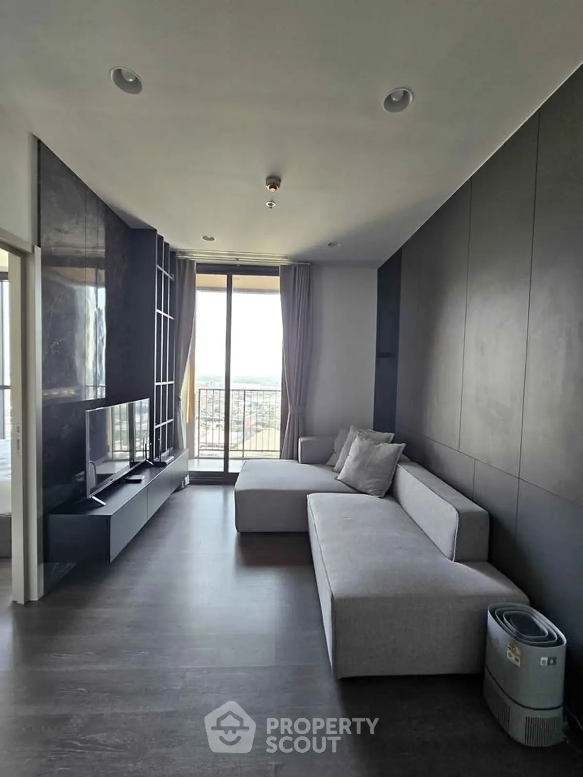 Modern living room with sleek design and large window offering stunning city views.