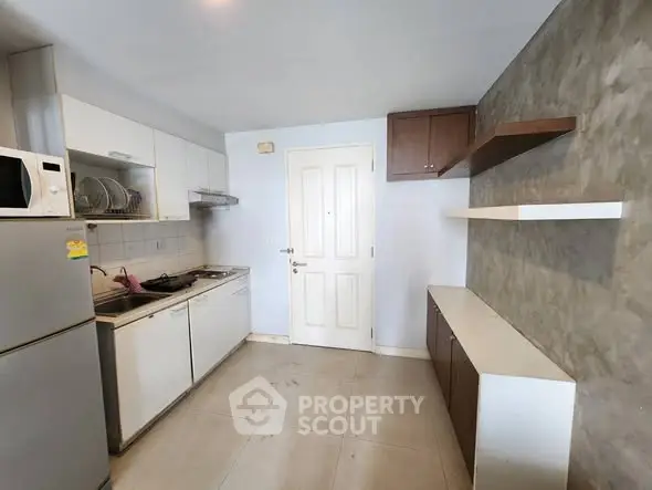 Modern kitchen with sleek cabinets and appliances in a compact layout.