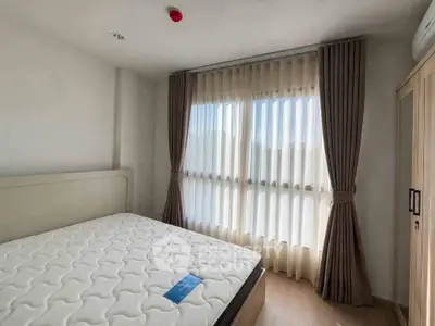 Bright and airy bedroom with large window and elegant curtains in modern apartment.