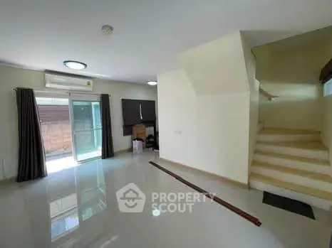 Spacious living room with modern staircase and sliding glass doors