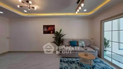 Spacious modern living room with stylish lighting and cozy seating area.