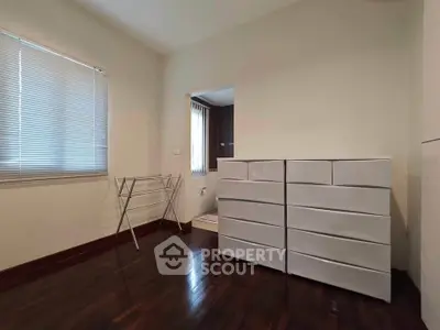 Spacious bedroom with hardwood floors and ample storage space