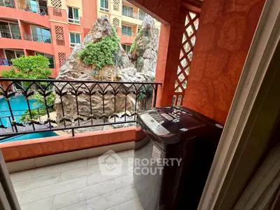 Charming balcony with washing machine overlooking a scenic rock garden and pool.