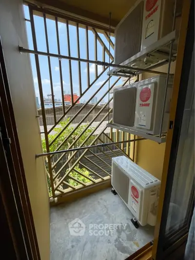 Compact balcony with air conditioning units and city view