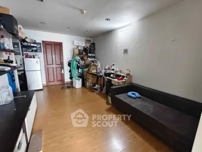 Cozy living room with wooden flooring and compact furniture, ideal for urban living.