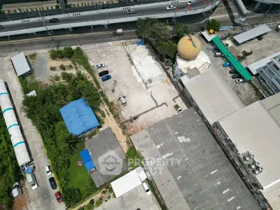 Aerial view of industrial property with parking and adjacent highway access.