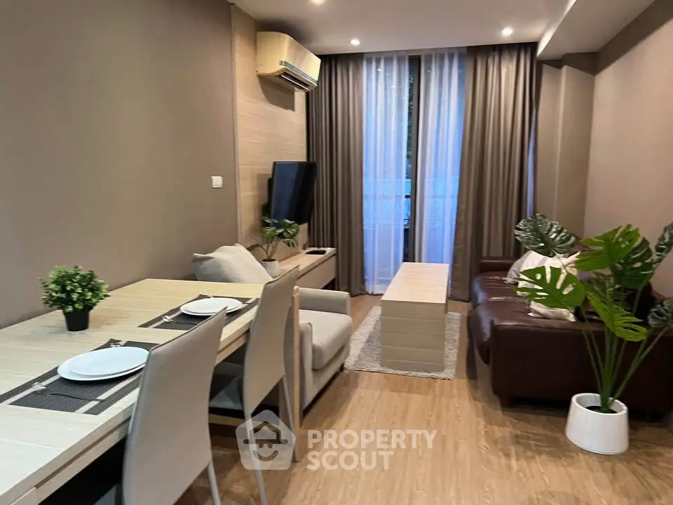 Modern living room with stylish decor and natural light, featuring a cozy seating area and dining space.