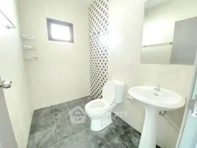 Modern bathroom with sleek design and geometric tile accent wall