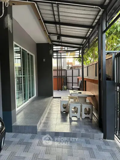 Modern outdoor patio with stylish seating and tiled flooring, perfect for relaxation and entertaining.