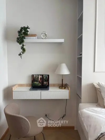 Modern study nook with built-in desk, chair, and decorative shelf in a stylish bedroom.