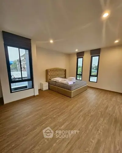 Spacious bedroom with modern design and large windows offering natural light and scenic views.