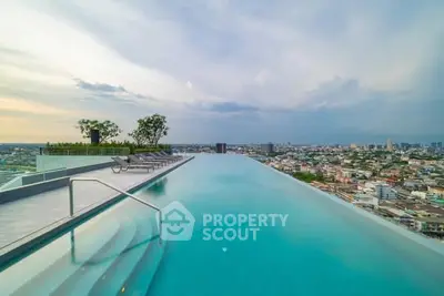 Stunning rooftop infinity pool with panoramic city views at sunset.