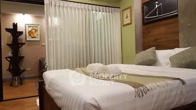 Cozy bedroom with modern decor and elegant lighting, featuring a comfortable bed and stylish furnishings.