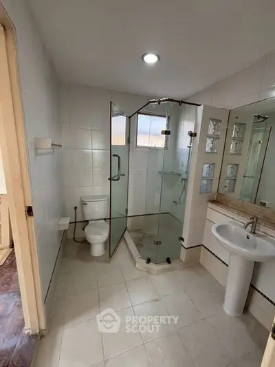 Modern bathroom with glass shower and sleek fixtures in a stylish home.