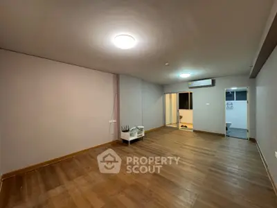 Spacious empty living room with wooden flooring and modern lighting