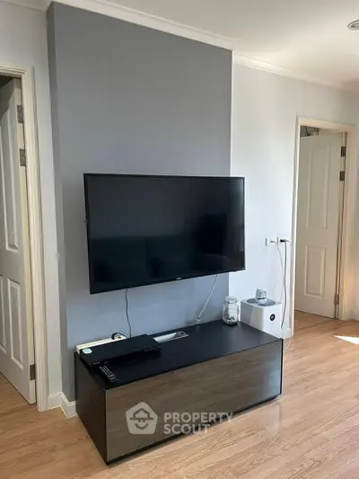 Modern living room with sleek TV setup and stylish wooden flooring