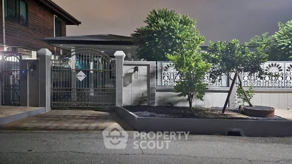 Charming residential property with gated entrance and lush greenery, perfect for serene living.