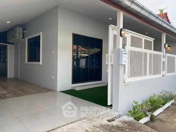 Charming single-story home with modern exterior and spacious driveway.