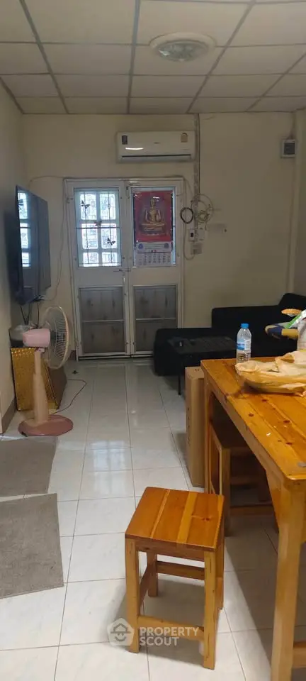 Cozy living room with wooden furniture and wall-mounted TV, perfect for relaxation.