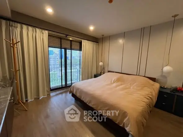 Spacious bedroom with large window and modern decor