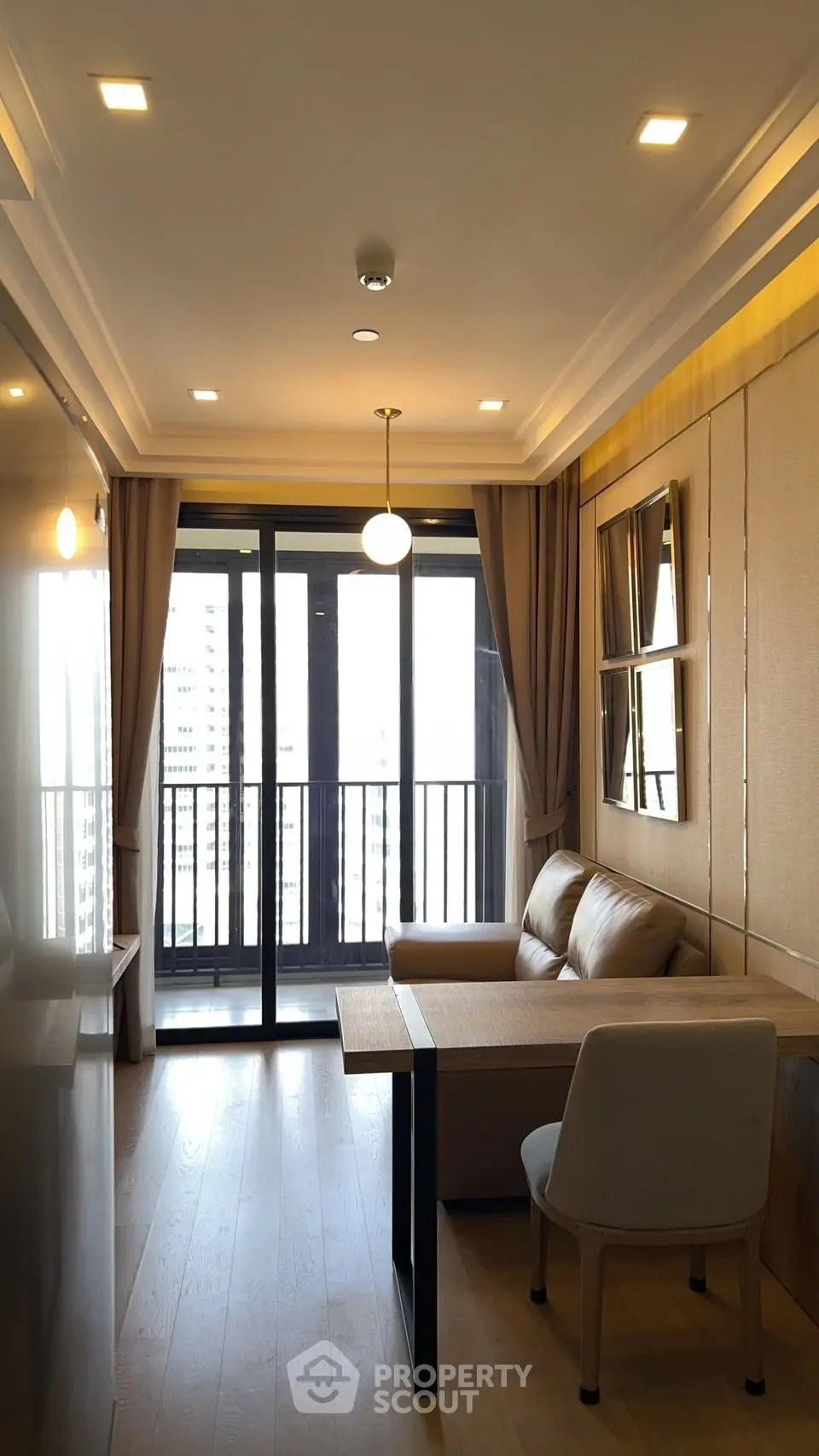 Modern living room with balcony view, featuring elegant decor and natural light.