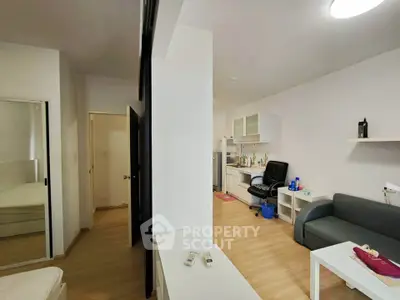Modern studio apartment with sleek furniture and open layout, featuring a cozy living area and compact kitchen.