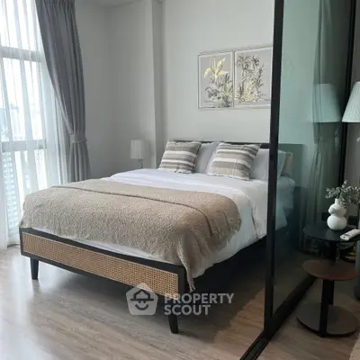 Modern bedroom with stylish decor and large window offering city views