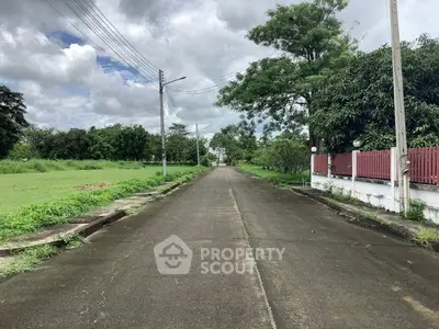 Scenic suburban street with lush greenery and clear skies, perfect for tranquil living.