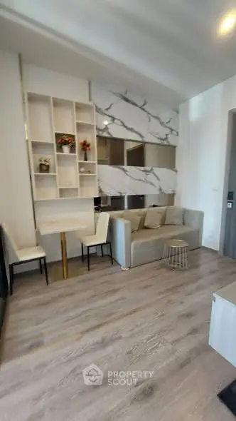 Modern living room with stylish decor and open layout, featuring elegant furniture and wooden flooring.