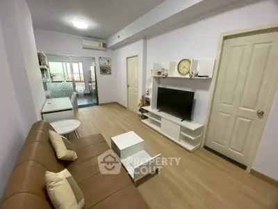 Modern living room with brown leather sofa and wall-mounted TV in stylish apartment.