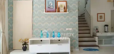 Charming living room with elegant wallpaper and stylish decor, featuring a modern white console and decorative vases.