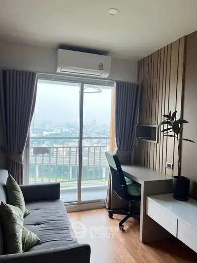 Modern living room with balcony view, featuring a cozy sofa and workspace, ideal for urban living.