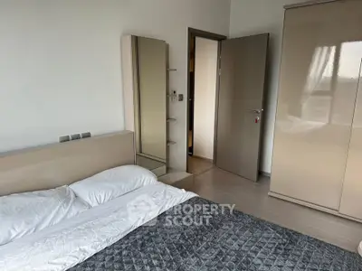 Modern bedroom with sleek wardrobe and cozy bedding in a stylish apartment.