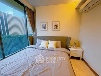 Cozy bedroom with large window and modern decor, perfect for relaxation.