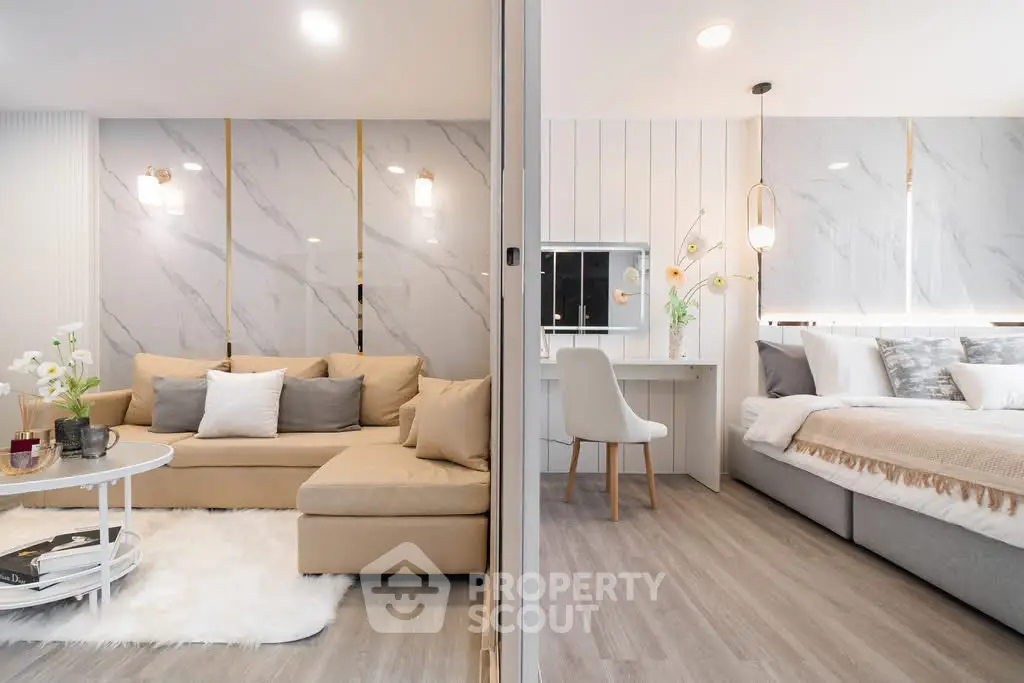 Modern open-plan living room and bedroom with elegant decor and neutral tones.