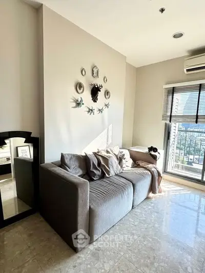 Stylish living room with cozy sofa and modern decor, featuring large windows for natural light.