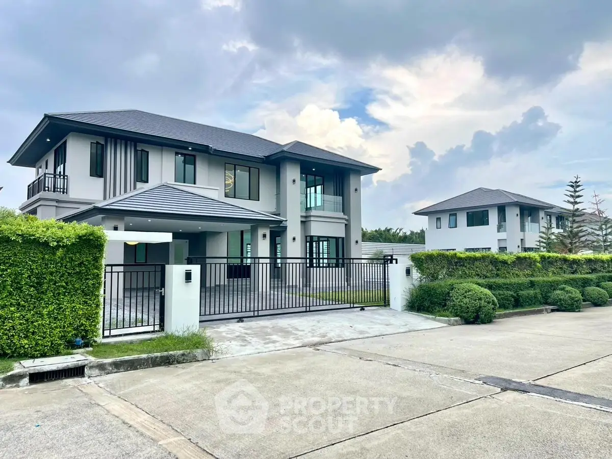 Modern luxury home with sleek design and spacious driveway in serene neighborhood.