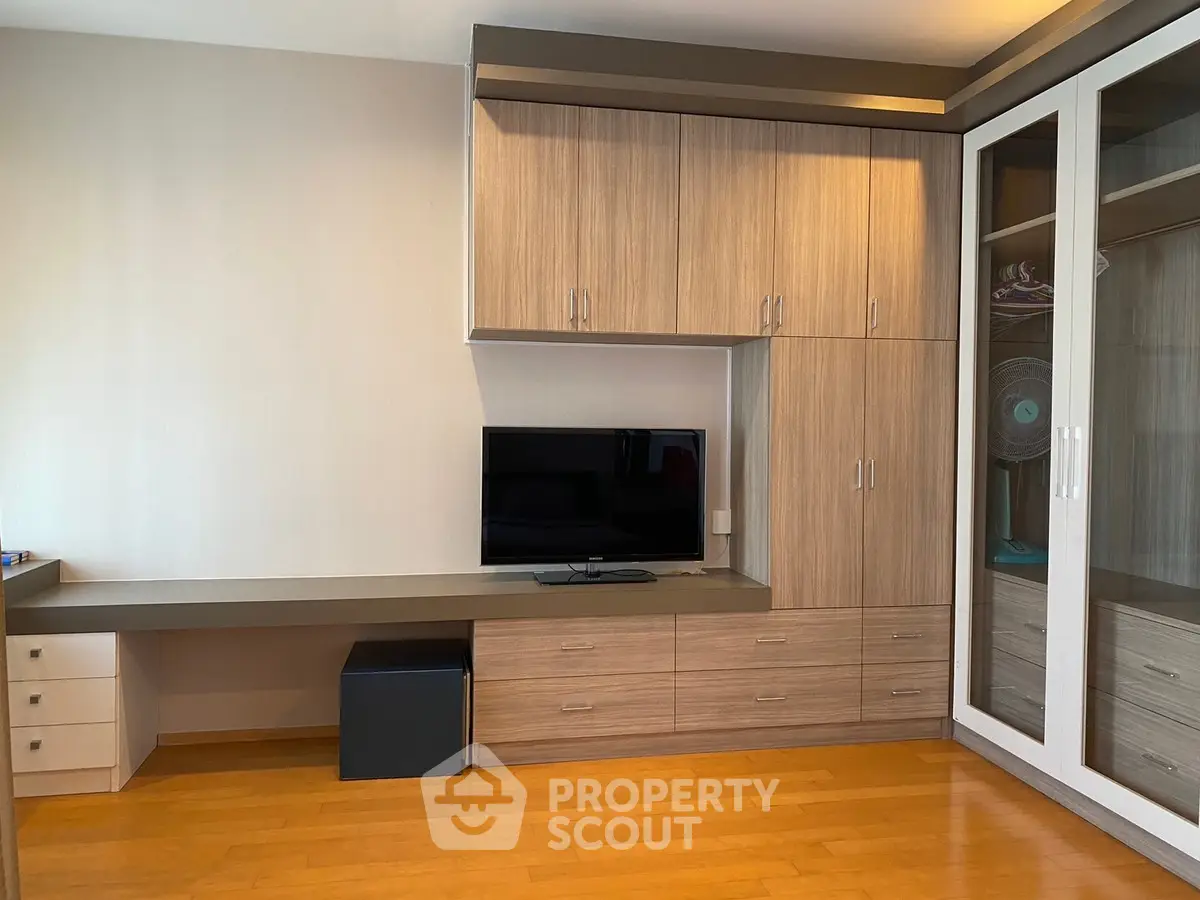 Modern bedroom with built-in wooden cabinets and sleek TV setup