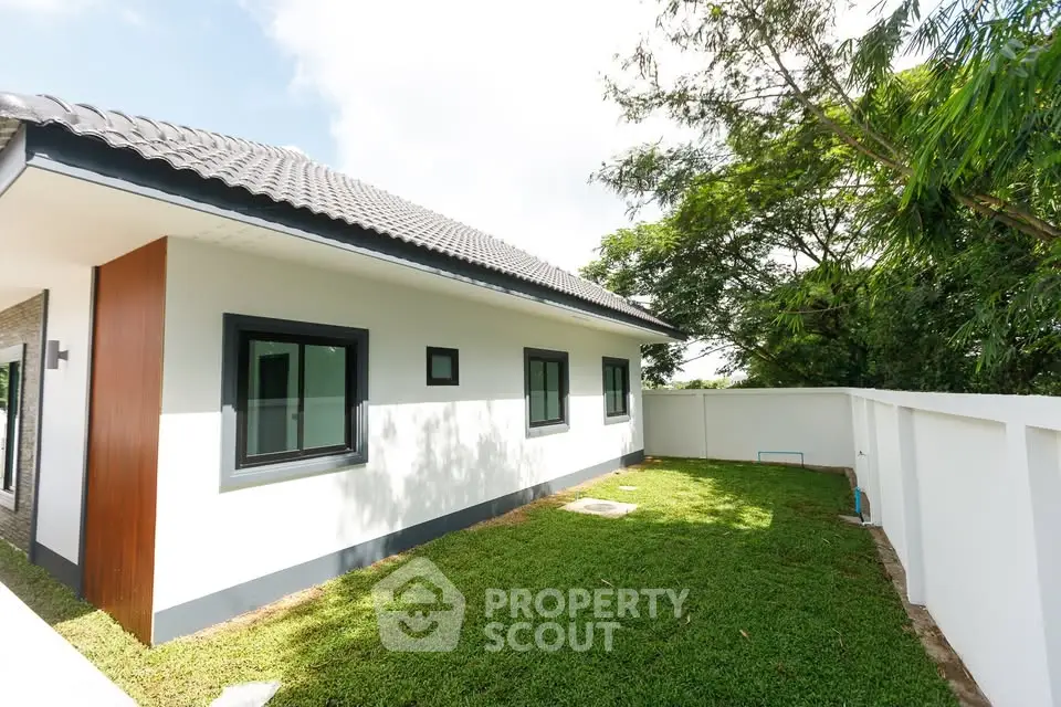 Modern single-story home with lush green yard and sleek exterior design.