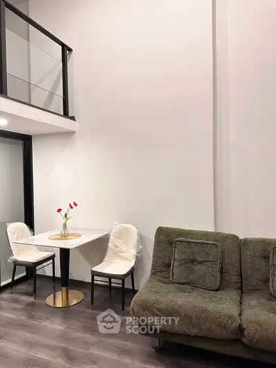 Modern living room with loft, stylish sofa, and elegant dining area in contemporary apartment.