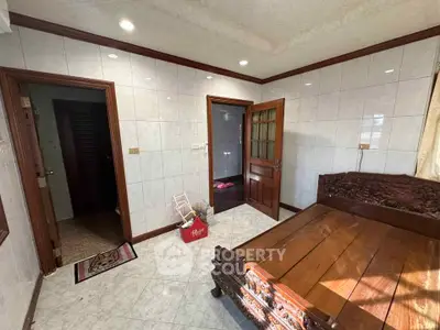 Charming bedroom with wooden bed and tiled walls, perfect for cozy living.