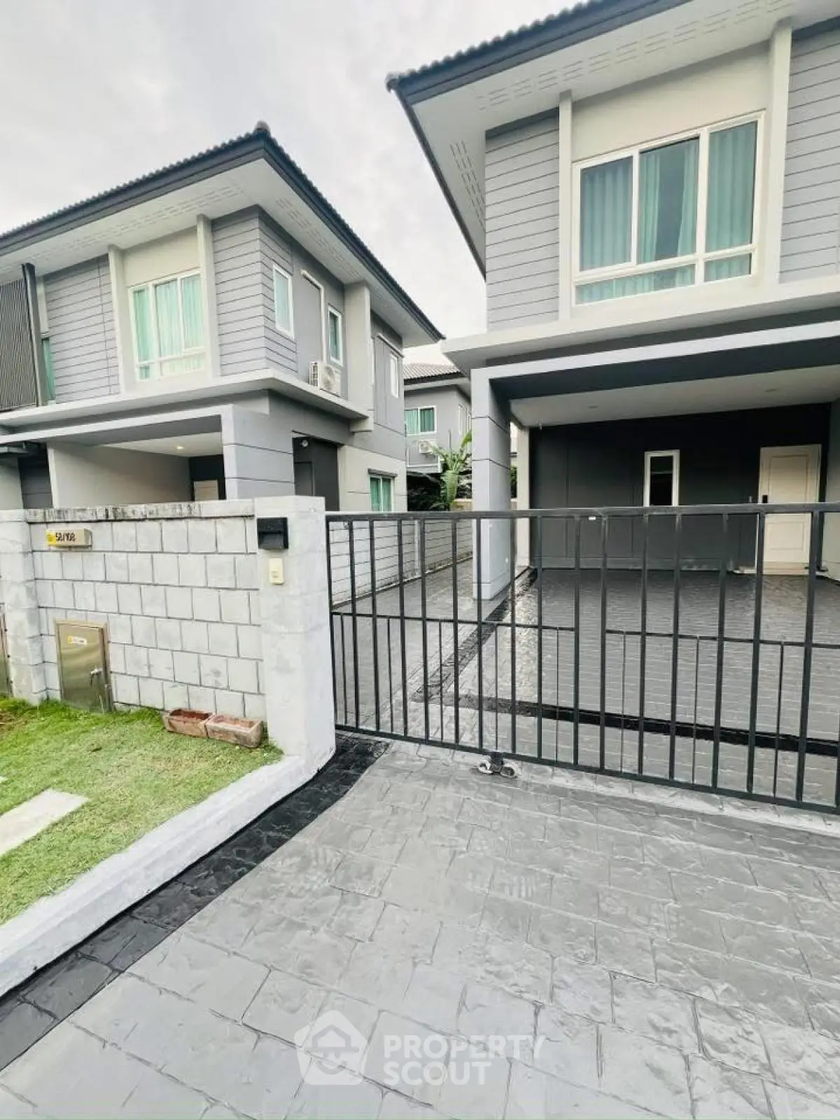 Modern two-story house with gated driveway and sleek exterior design
